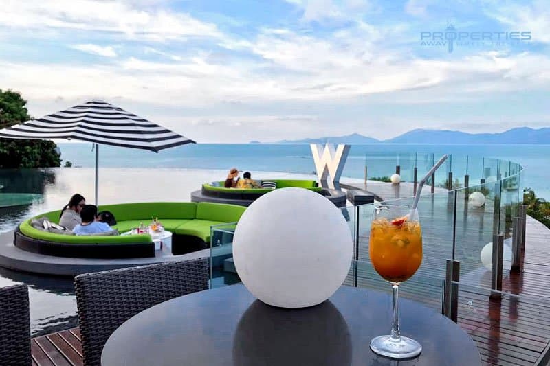 Poolside lounge area with an infinity pool and sea view at a Koh Samui resort