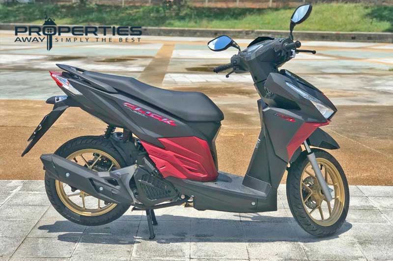 A black and red automatic scooter parked on a paved area on Koh Samui